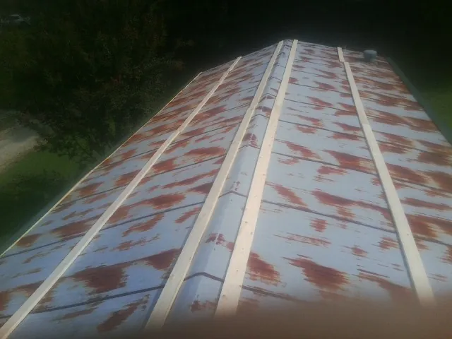 Rusted metal roof panels with new wood purlins before replacement — Storm Damage Roof Repair in Falcon by Roofing Brothers