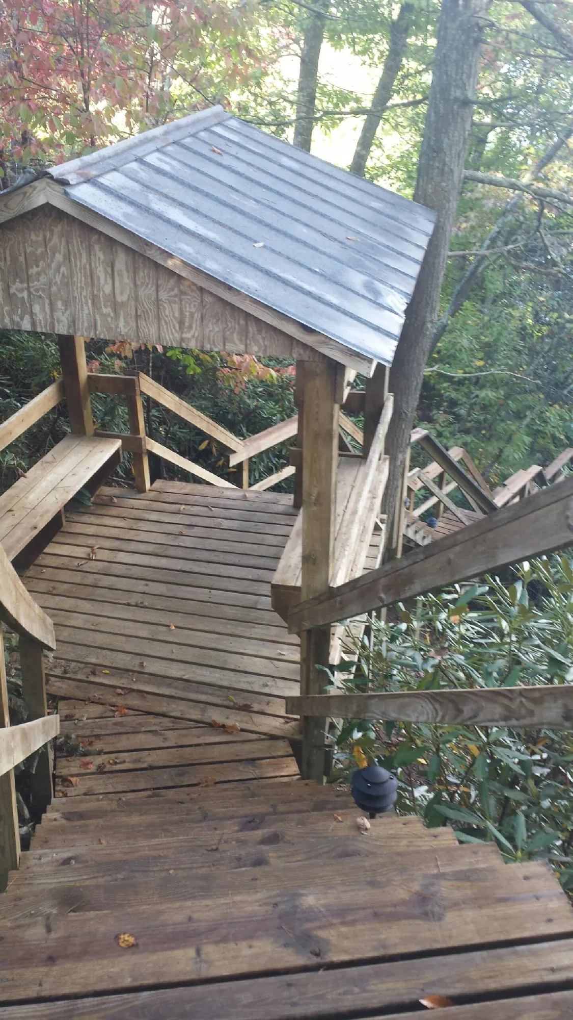Metal roofed shelter over wooden steps on a wooded walkway — Skylight Repair & Installation work by our crew in Falcon