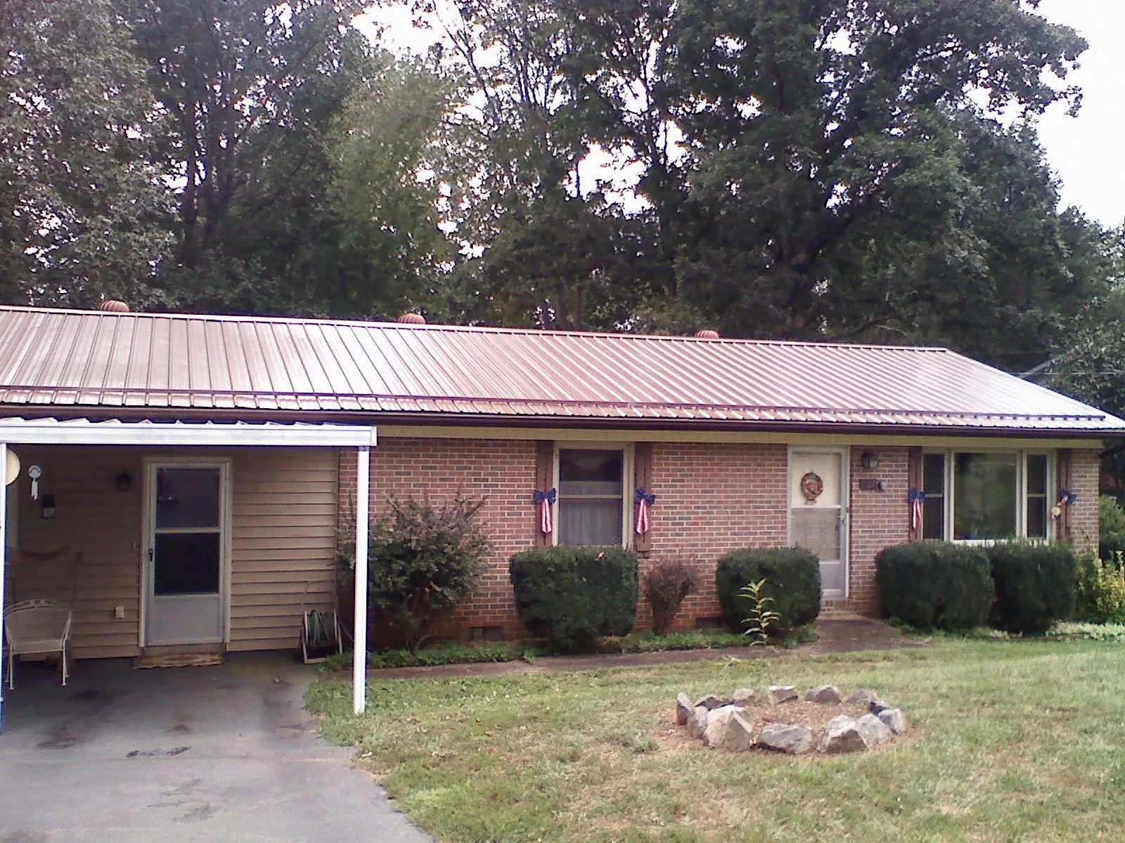Bronze metal roof and carport on a brick ranch home — Roof Repair work by our crew in Falcon